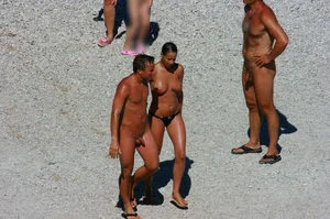 Nudist couple on the beach, girl has amazing tits and nice ass in a thong