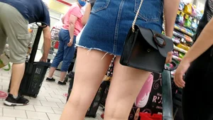 Juicy slim legs and a flat booty in a fringed denim skirt closeup creepshot on the street
