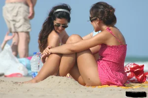 2 topless girls at the beach in thongs