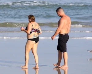 Thick flat assed tattooed lady on the beach in a bikini