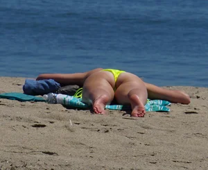Sexy ass blonde milf on the beach in a thong with cameltoe and bending over