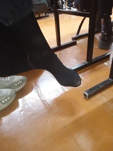 College teen's feet in black pantyhose, closeups in class