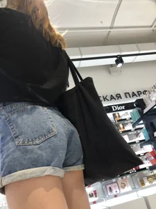 Skinny candid teen's legs and booty in denim shorts closeups at the store