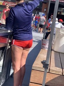 Bunch of girls in various outfits at a Cardinals baseball game