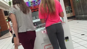 Little blonde teen in grey leggings at the mall with her friends