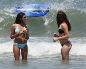 Brunette and redhead on the beach in bikinis looking sexy