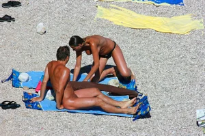 Nudist couple on the beach, girl has amazing tits and nice ass in a thong