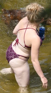 Chunky blonde enjoying some drinks in the water in her purple bikini