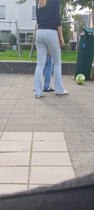 Tall candid teen wearing tight jeans playing on the street