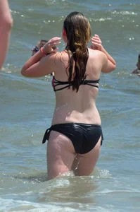 Cute beach girl in little bikini in the water