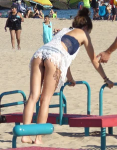 Beach teen in semi thong bikini under see through dress on the beach
