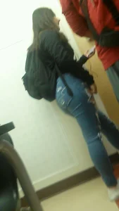 College girl in tight jeans in a hallway