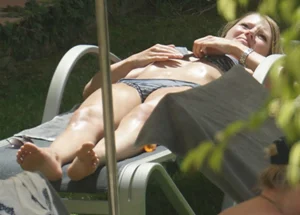 Skinny girl laying out in her bikini has pussy lip slip