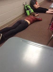College teen in tight jeans laying on the floor