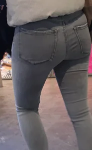 Girl with a tight ass in grey jeans going up the escalator
