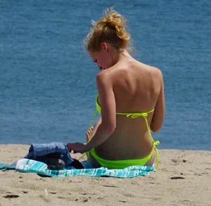 Sexy ass blonde milf on the beach in a thong with cameltoe and bending over