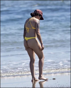 Sexy tattooed beach brunette with a great ass in yellow thong bikini