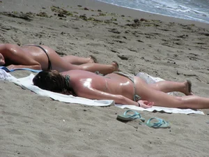 Topless girl with tan lined tits and in a black thong bikini