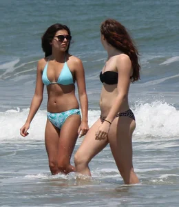 Brunette and redhead on the beach in bikinis looking sexy