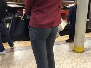 Blonde in tight dress pants waits for the train