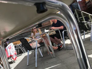 Under the table creepshot of hot legs in a street cafe
