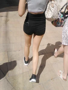 Cute babe in short black denim shorts and tank top