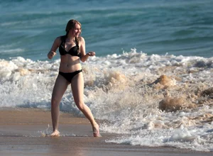 Cute bikini girl in the water in a black bikini