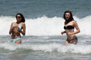Brunette and redhead on the beach in bikinis looking sexy