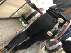 Sexy Round Ass in Tight Pants - Girl Holding a Skateboard on a Subway Escalator