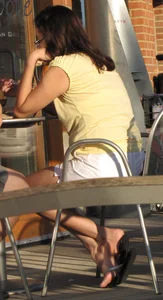 Lady in flop flops while eating showing her feet