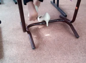Feet in Pantyhose With High-Heeled Shoes Taken Off Under Desk Creepshot