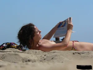 Topless beach milf looking sexy in a tiny g-string bikini