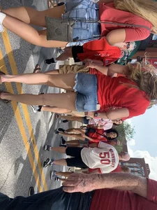 Bunch of girls in various outfits at a Cardinals baseball game