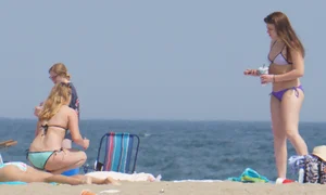 Cute girls in light blue and purple bikinis on the beach