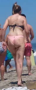 Chunky beach blonde babe in a pink thong bikini