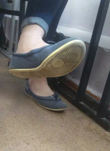 Feet in Flats Classroom under Desk Closeup Photo