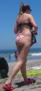 Chunky beach blonde babe in a pink thong bikini