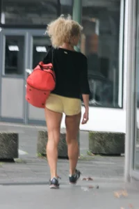 Blonde looking sexy walking in short yellow shorts