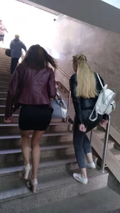 Hot girl walking up the stairs, wearing a skirt, pantyhose and high-heeled shoes