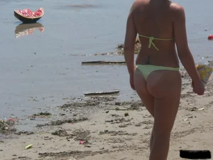 Sexy blonde on the beach in a yellow thong bikini