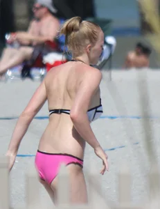 Skinny blonde girl on the beach in her pink and white bikini