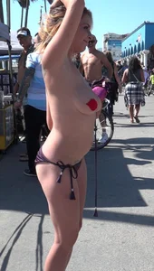 Sexy topless blonde with pasties on her nipples bouncing a ball and posing for cameras