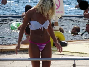 Tanned blonde looking sexy at the pool in thong