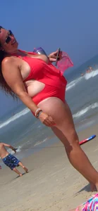 Thick lady on the beach with big boobs in a red swimsuit
