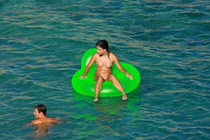 FKK Nudists playing in the water with floater