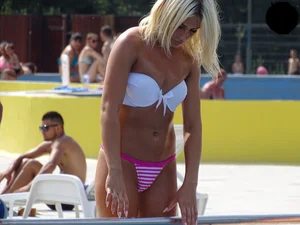 Tanned blonde looking sexy at the pool in thong