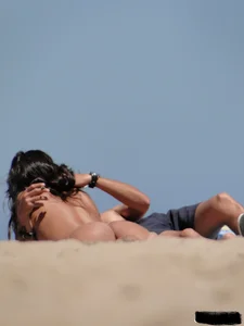 Topless lady on the beach in a gold thong with a nice ass