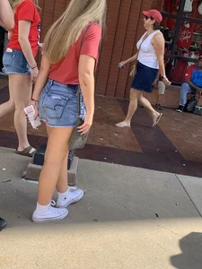 Bunch of girls in various outfits at a Cardinals baseball game