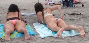 Pink and patterned bikini girls' asses laying on the beach