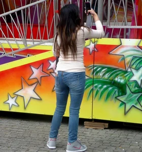 Young candid girl in tight blue jeans at the fun fair
